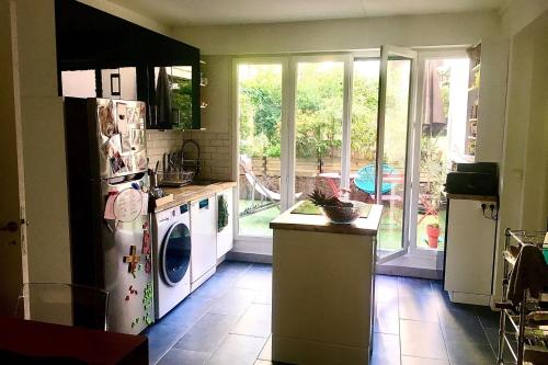 une cuisine avec un réfrigérateur et une machine à laver dans l'établissement Apartment with garden near Montmartre, à Paris