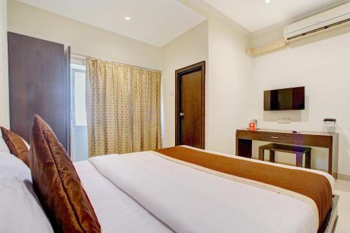 a bedroom with a bed and a desk and a television at Collection O 9796 Hotel Alekhya Residency in Hyderabad