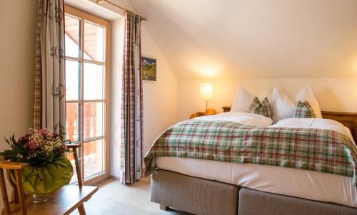 a bedroom with a bed and a large window at Seewirt Zauner - contactless check in in Hallstatt