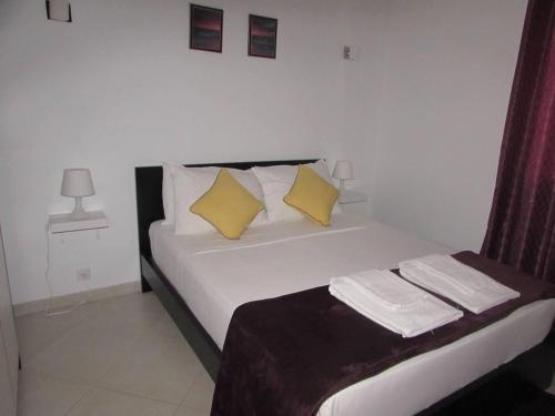 a bedroom with a bed with two yellow pillows at Cozy 1 bed apartment with garden and pool view in Santa Maria