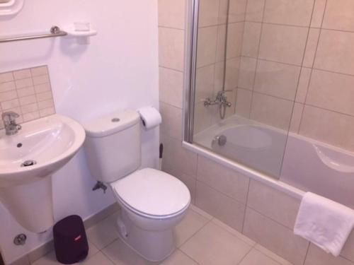 a bathroom with a toilet and a sink and a shower at Cozy 1 bed apartment with garden and pool view in Santa Maria