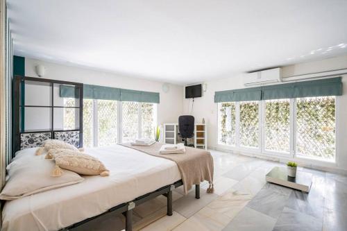 1 dormitorio con 1 cama grande y ventanas grandes en ARRIAGA ALTO- Coqueto duplex. Parking gratuito, en Madrid