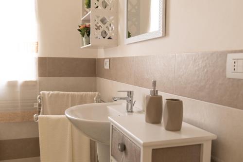uma casa de banho com um lavatório branco e um espelho. em Casa Vacanze Cicerone em Martina Franca