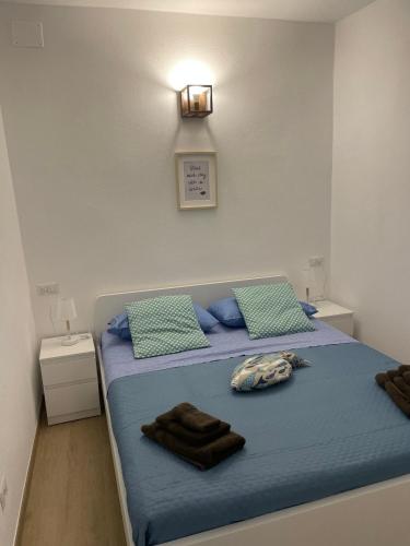 a bedroom with a bed with blue sheets and blue pillows at Cà di GIACO in Moneglia