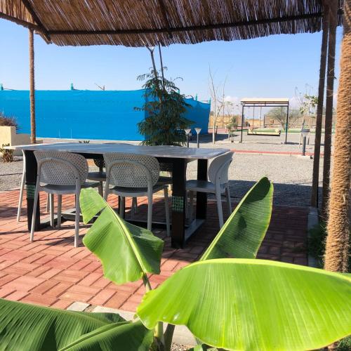 a table and chairs on a brick patio at afnan farm in Al Ḩamrānīyah