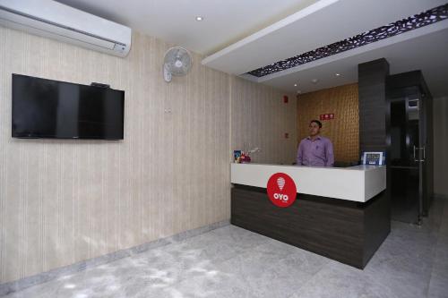 a man standing at a counter in a hotel room at Niharika Guest House in Guwahati