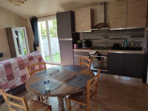 une cuisine et une salle à manger avec une table et des chaises en bois dans l'établissement Family house carcanaise, à Carcans