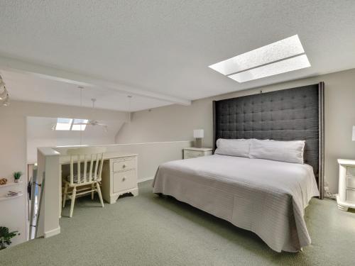 1 dormitorio con 1 cama grande y escritorio en 359 Edgewater Inn, en Charlevoix