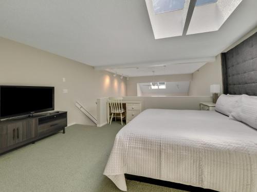 a bedroom with a bed and a flat screen tv at 359 Edgewater Inn in Charlevoix