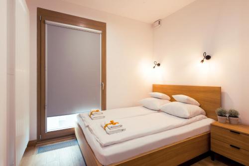 a bedroom with a bed with a large window at ApartHotel Kolejowa Apartamenty in Warsaw