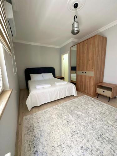 a bedroom with a bed and a large rug at ima Apartmanı in Trabzon