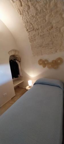 1 dormitorio con cama blanca y techo de piedra en Dimora Luglio 1651, en Ostuni