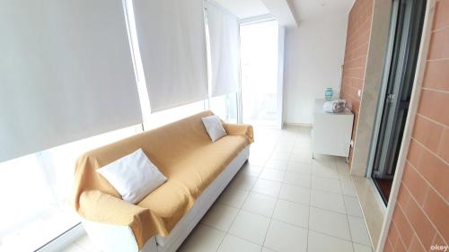 un soggiorno con divano e cuscini sopra di Wow Waterfront Apartment - Bari Fesca a Bari