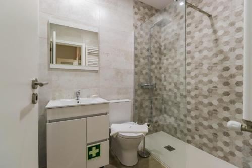 uma casa de banho com um WC, um lavatório e um chuveiro em Sunshine Apartment - Modern Ap Near the Beach em Viana do Castelo