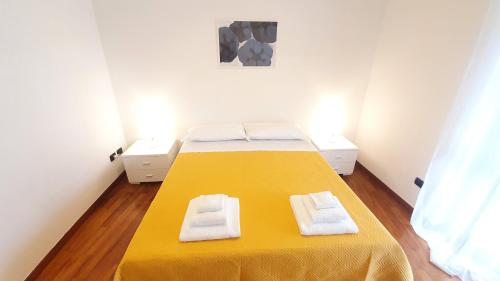 una camera da letto con un letto giallo con due asciugamani di Wow Waterfront Apartment - Bari Fesca a Bari