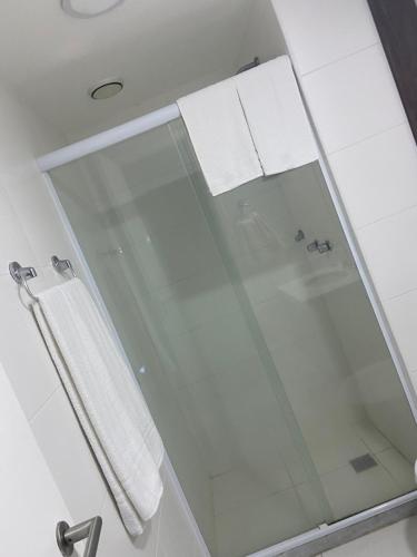 Baño con puerta de ducha de cristal y toallas blancas en Suite Rio stay, en Río de Janeiro
