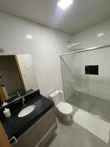 a bathroom with a sink and a toilet and a shower at Vêneto Flat Residence (AP-13) in Primavera do Leste