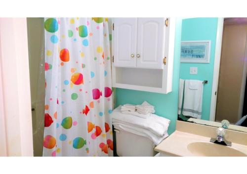 a bathroom with a shower curtain and a toilet at Gulf Shores Plantation Condos in Gulf Shores
