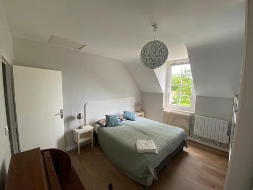 a bedroom with a bed and a window at Chambres d'Hôtes Ferme de Kereven in Clohars-Fouesnant