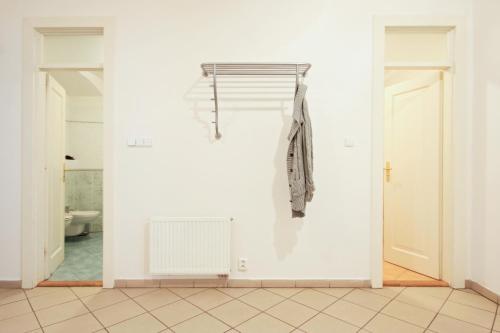 un bagno bianco con un cappotto appeso a un muro di Quadrio Bedroom Central Apartment a Praga