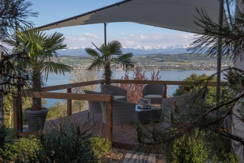 a balcony with chairs and a view of the water at Le Mont-Vully - Hôtel Restaurant in Haut-Vully