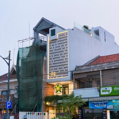 a tall white building with a lot of windows on it at Aborest Tropical Hostel in Siem Reap