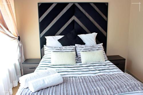 a bedroom with a large bed with white pillows at THE GLOBAL LINK HUB in Pretoria