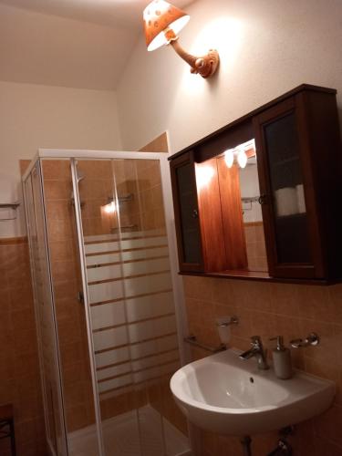 a bathroom with a shower and a sink and a mirror at AFFITTACAMERE DORGALI B&B da ZIETTO in Dorgali