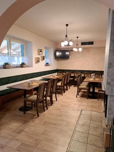 a dining room with wooden tables and chairs at Penzion a Restaurace Na Záložně in Kobylí