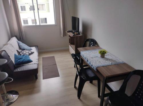 sala de estar con mesa de comedor y sofá en Apartamento novo wi-fi + TV, en Ponta Grossa