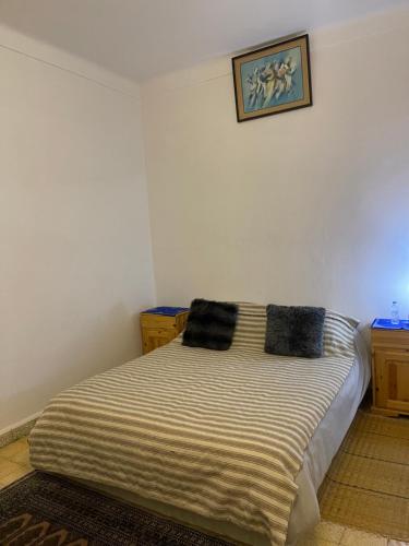 1 dormitorio con 1 cama con 2 almohadas en Maison Mina, en Oualidia