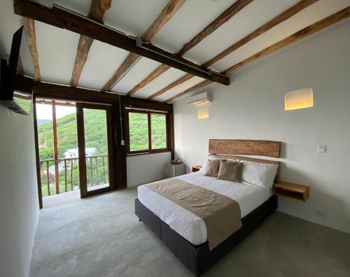 sypialnia z łóżkiem i dużym oknem w obiekcie Akela Gaira Hotel w mieście Santa Marta