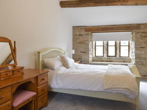 een slaapkamer met een bed, een dressoir en een raam bij Higher Kirkstall Wood Farm in Ingrow