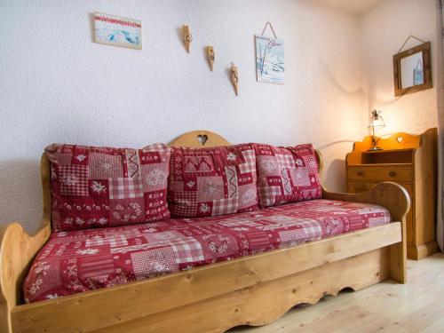 Cette chambre comprend un lit avec des oreillers rouges et blancs. dans l'établissement Studio cabine moderne pour 4 pers, centre Valloire, balcon, parking, proche remontées et commerces - FR-1-263-13, à Valloire