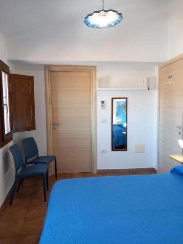 a bedroom with a blue bed and a chair at AFFITTACAMERE DORGALI B&B da ZIETTO in Dorgali