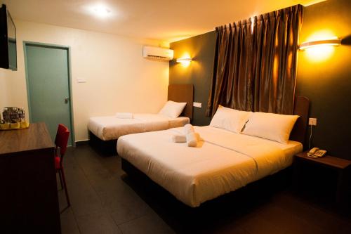 A bed or beds in a room at Micasa Hotel Labuan