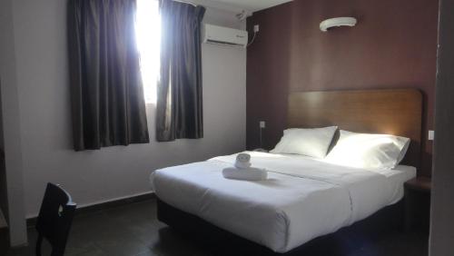 a bedroom with a large bed with a white blanket at Micasa Hotel Labuan in Labuan