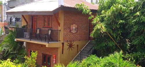a brick house with a balcony and trees at Negombo The Nature Villa and Cabanas in Negombo