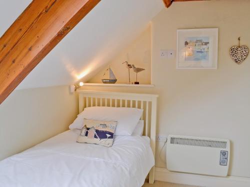 a bedroom with a white bed in a attic at Mainbrace in Port Isaac