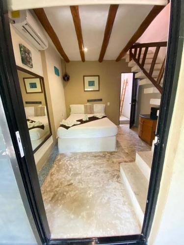 a bedroom with a bed in a room with water on the floor at La Constanza de Rulo in Holbox Island