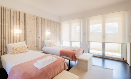a hotel room with two beds and a window at Azores Mountain View in Ribeira Grande