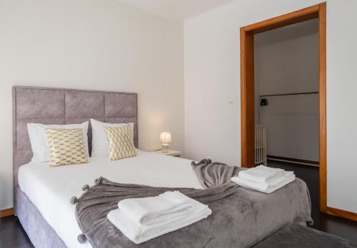 a bedroom with a large white bed with towels on it at Azores Mountain View in Ribeira Grande
