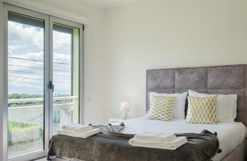 a bedroom with a large bed with a large window at Azores Mountain View in Ribeira Grande