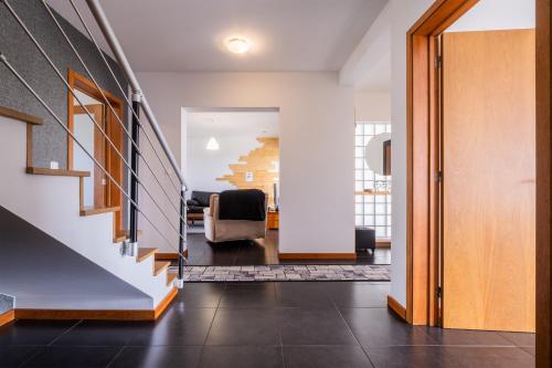 a hallway of a house with a staircase and chairs at Azores Mountain View in Ribeira Grande