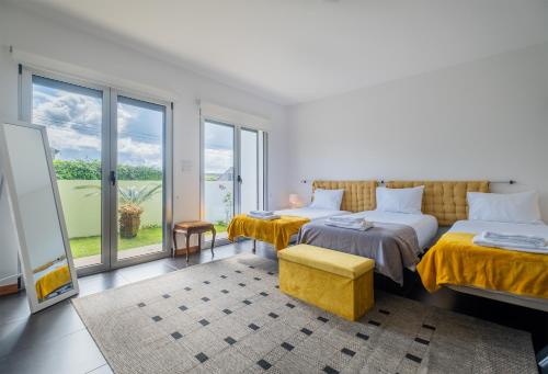 um quarto com 2 camas e uma grande janela em Azores Mountain View na Ribeira Grande