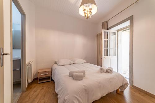 a bedroom with a bed with towels on it at Un pied à terre avec terrasse à la Cathédrale - Une Nuit à Nîmes in Nîmes