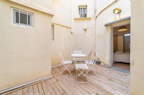 a patio with a table and chairs on a deck at Un pied à terre avec terrasse à la Cathédrale - Une Nuit à Nîmes in Nîmes