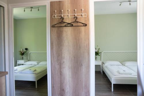 twee spiegels in een kamer met twee bedden bij Tulipán Apartman in Eger