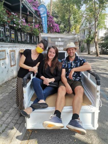 a group of three people sitting on a bench at Büyükada Anastasia Meziki History Mansion in Buyukada