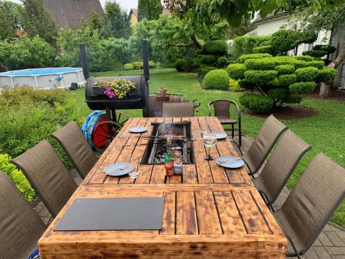 un tavolo di legno in un cortile con sedie intorno di Jaani Accommodation a Pärnu